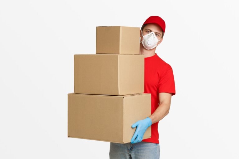 A man with red shirt and red had wears gloves and hold delivery boxes