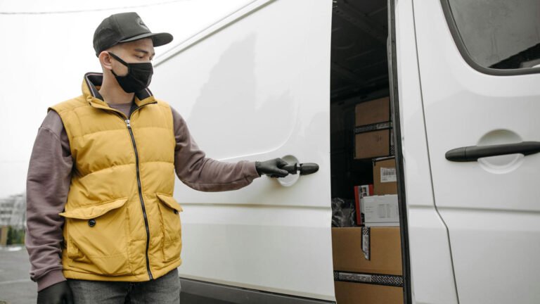 A delivery man with black face mask open truck door