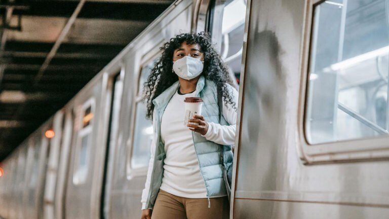 A woman wears white N95 mask exit from subway train